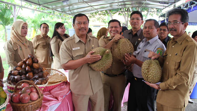 ===BUAH LOKAL=== Asisten Kesra Mugeni (ketiga dari kanan) dan Kepala Dinas Pertanian S. Ginting (kanan) menunjukkan hasil produk buah durian lokal asli Kutim. (RONALL/HUMAS)
