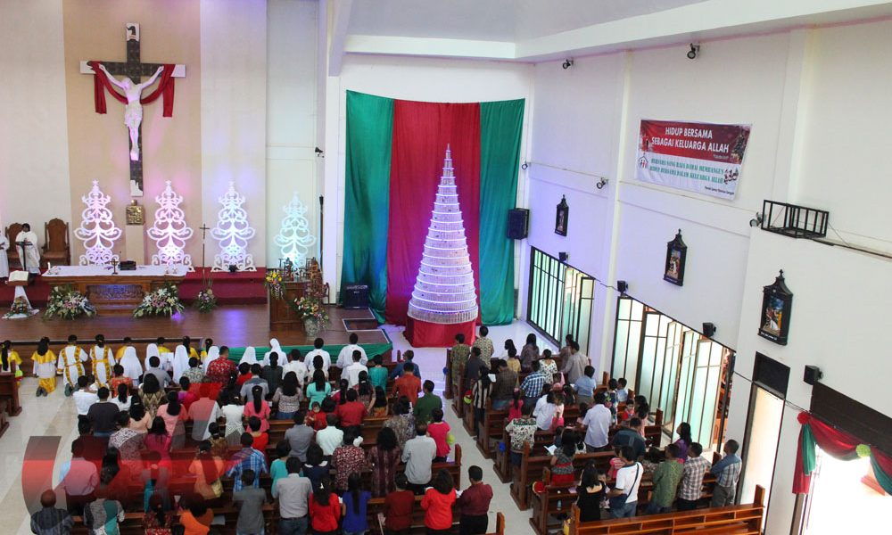 Pohon Natal dari rangkaian botol aqua dipajang di depan gereja saat Misa Natal berlangsung di gereja Katolik Sangatta.